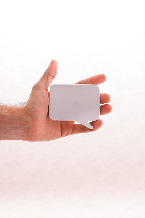 Free A hand holding a blank white speech bubble sticker, perfect for mockups or conceptual designs. Stock Photo