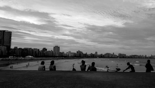 Gray Scale Photo of Group of People Near on Beach