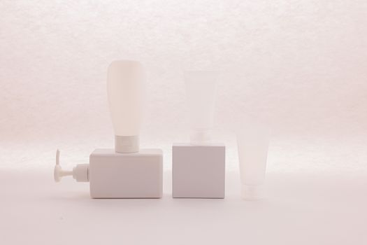 Three white cosmetic containers on a soft background, ideal for product mockups.. three, white, cosmetic