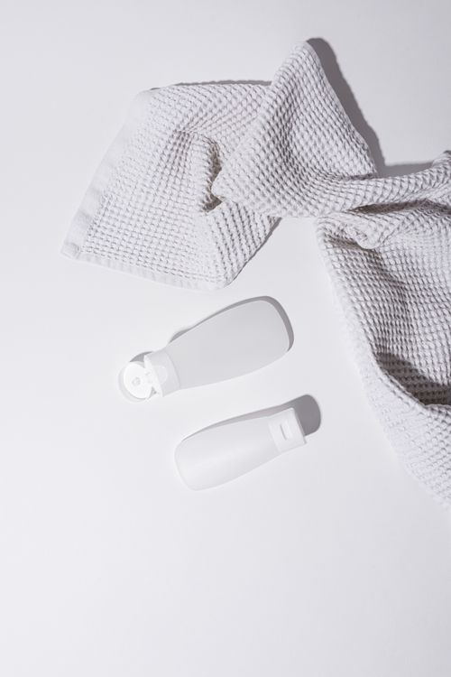 Folded waffle towel with two unbranded bottles, photo by Cup of Couple on Pexels
