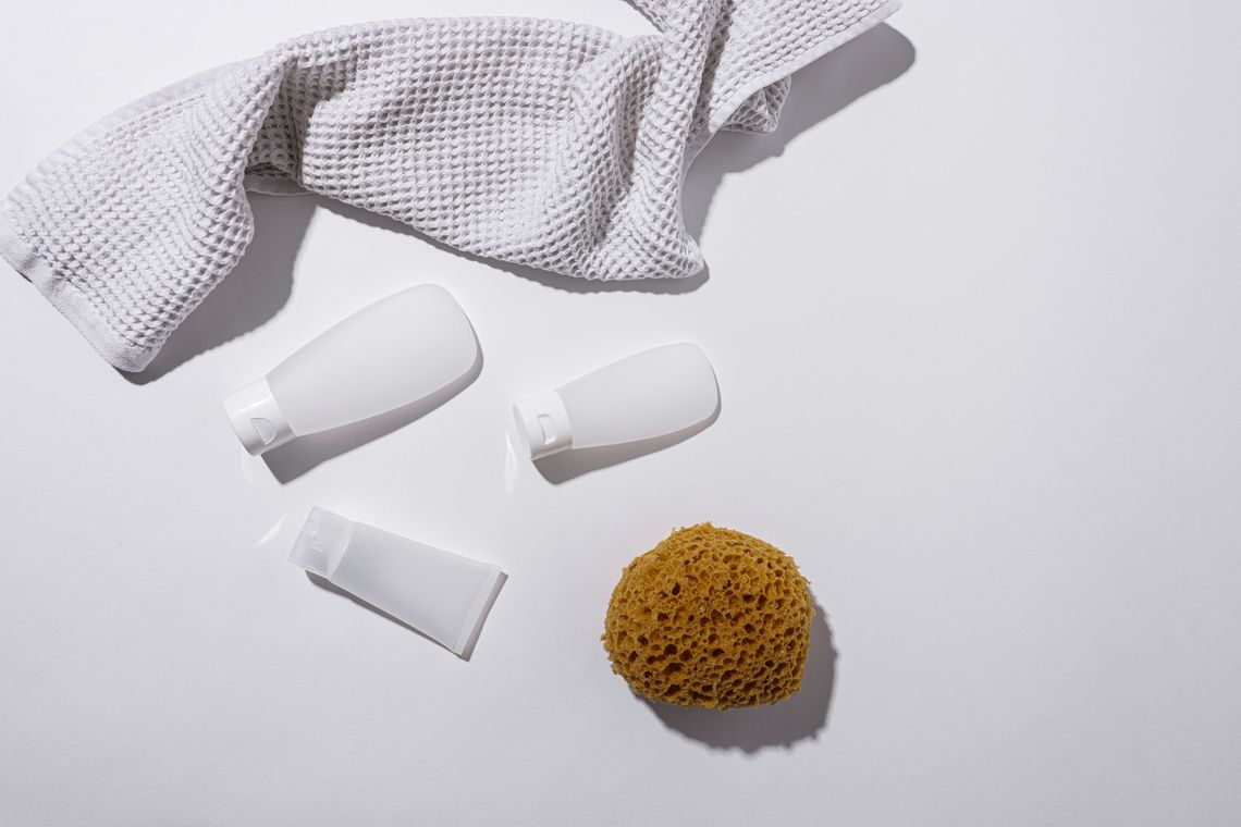 Bath and body products arranged with a sponge and soft towel