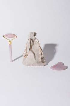 A minimalist setup featuring a jade roller, gua sha, and pouch on a white background.