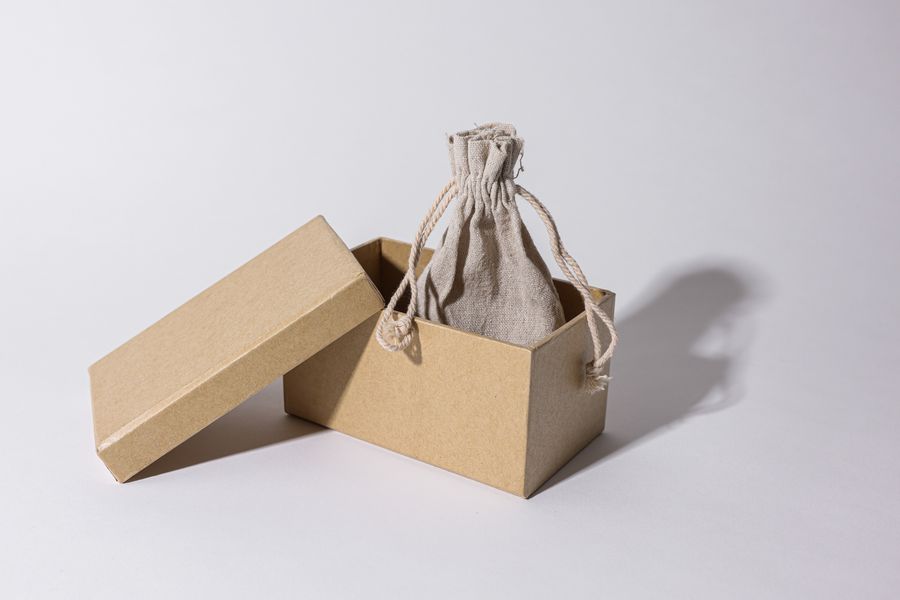A linen pouch inside an open kraft box