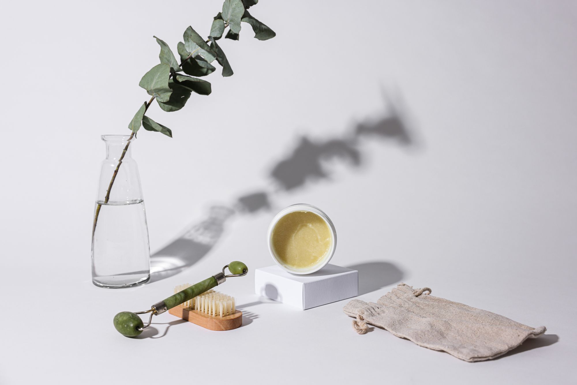 Facial roller, skincare brush, and beauty products arranged in a studio
