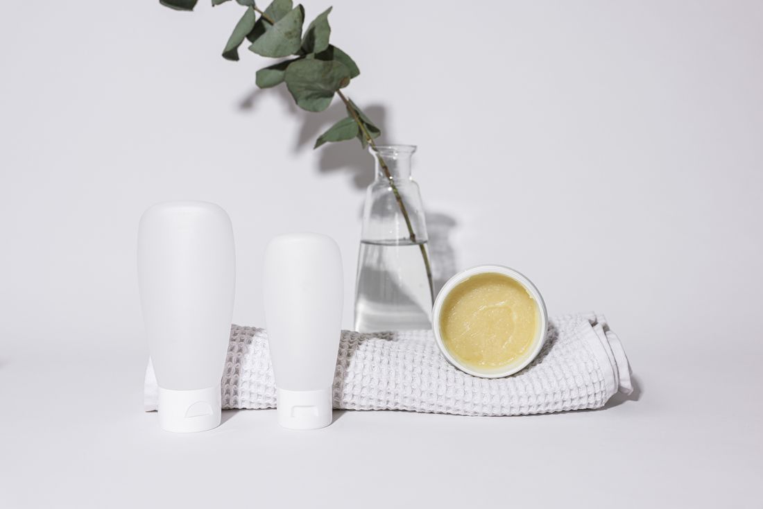 Unlabelled haircare bottles with a eucalyptus sprig — photo by Cup of Couple on Pexels