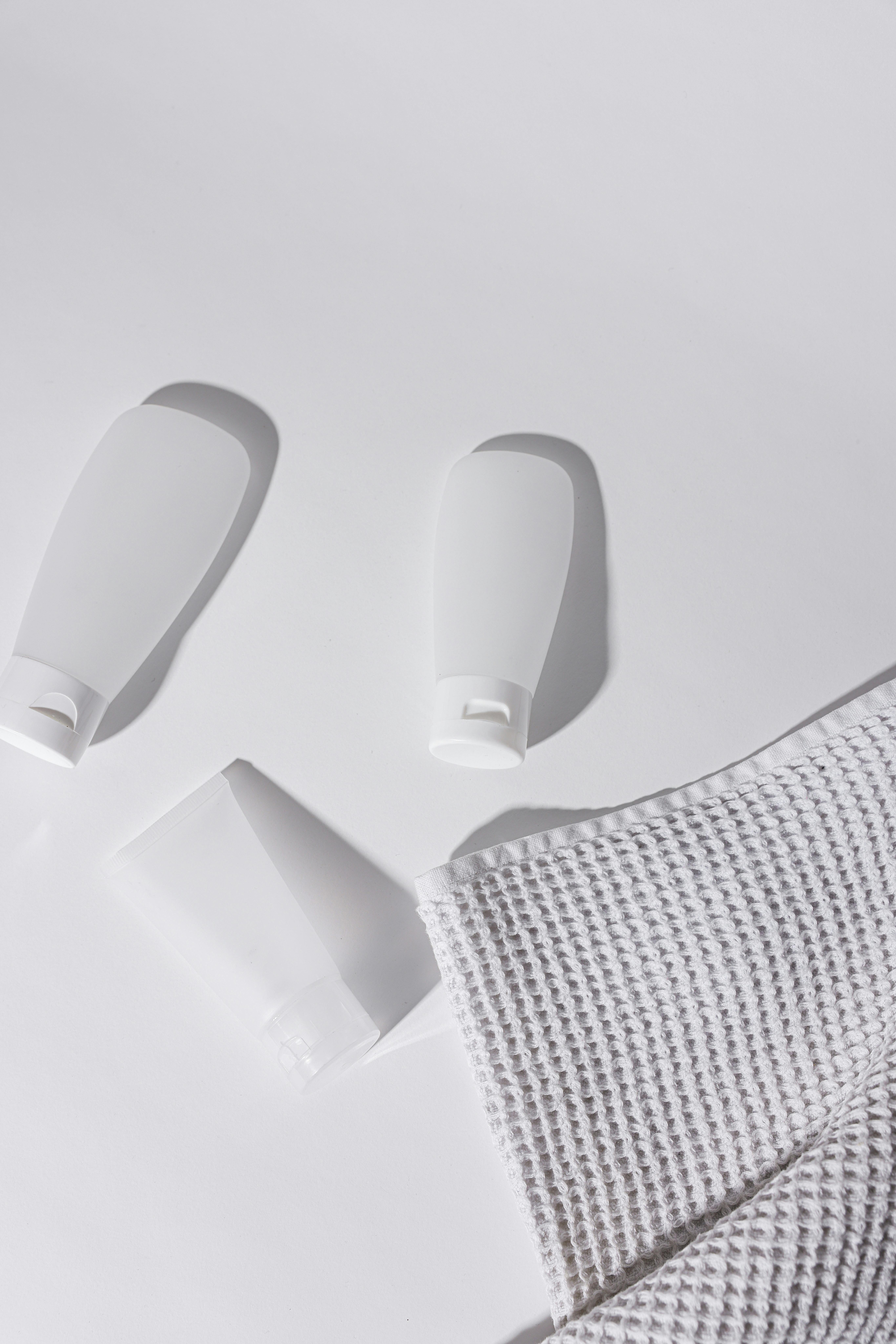 a tube cream beside a face towel