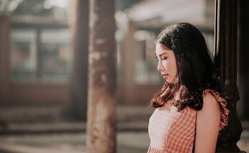 Free Photography of Woman Leaning on Black Post Stock Photo