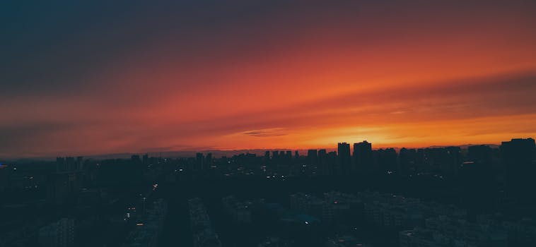 Silhouette of city skyline under a vibrant sunset sky, capturing urban beauty.