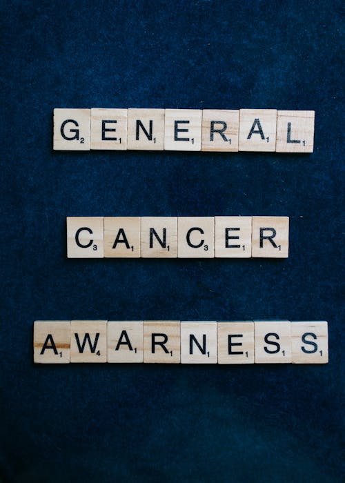 General Cancer Awareness Scrabble Tiles on Blue Surface