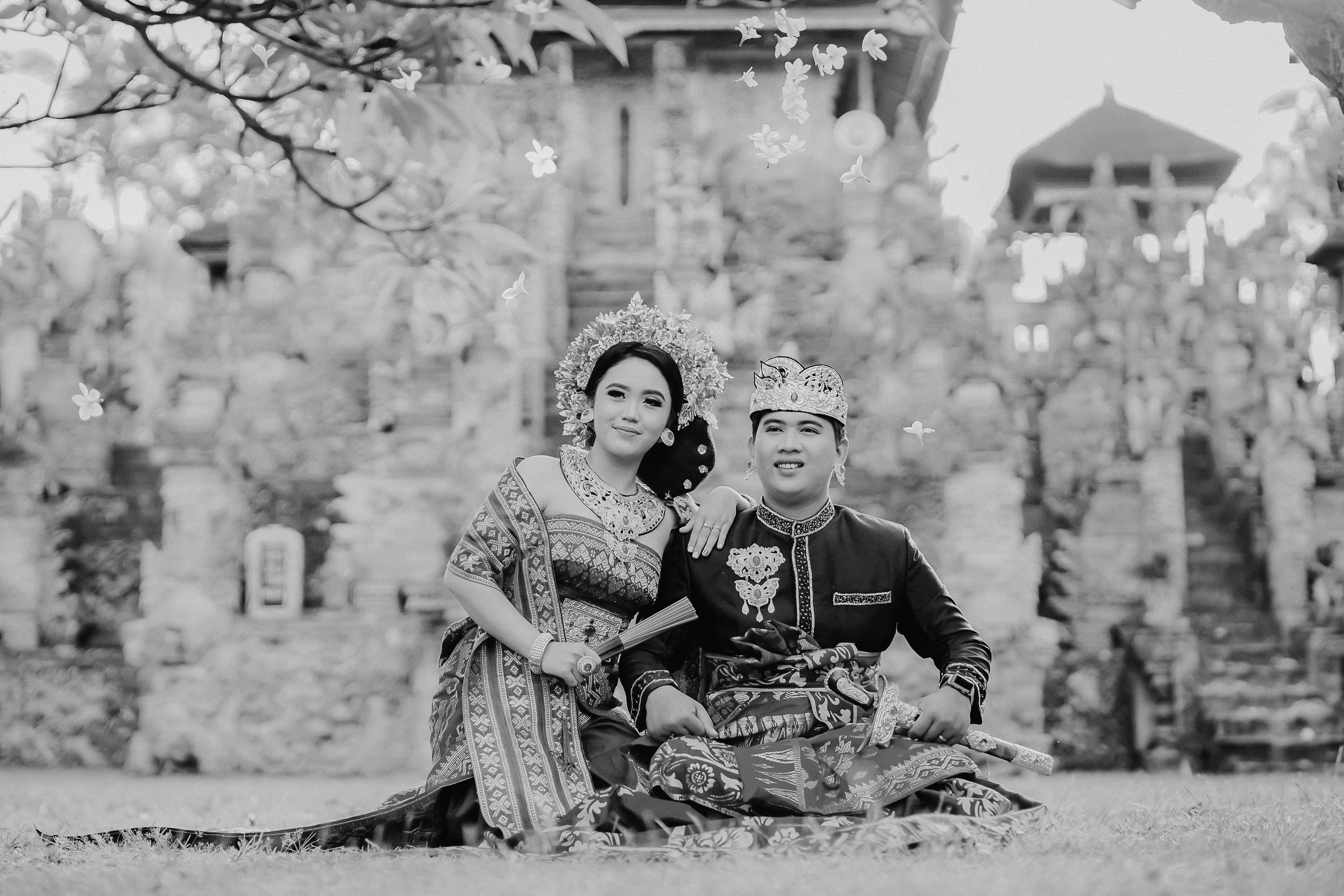 A couple in traditional attire at a historical site, celebrating their cultural heritage in style.