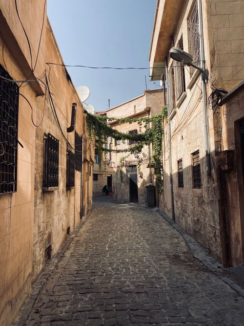 Free Explore a historic cobblestone alleyway in an old town, featuring rustic architecture and a peaceful path. Stock Photo