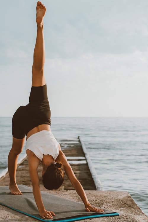 A Woman Bending Her Body While Raising Her Leg