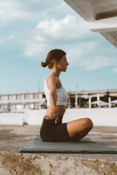 Woman doing yoga in a serene urban environment, embracing tranquility and wellness.