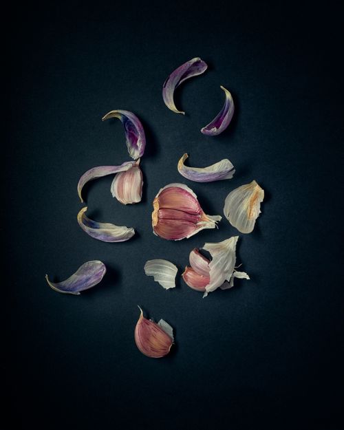 Free Aesthetic display of peeled garlic cloves against a dark surface, highlighting texture and color contrast. Stock Photo
