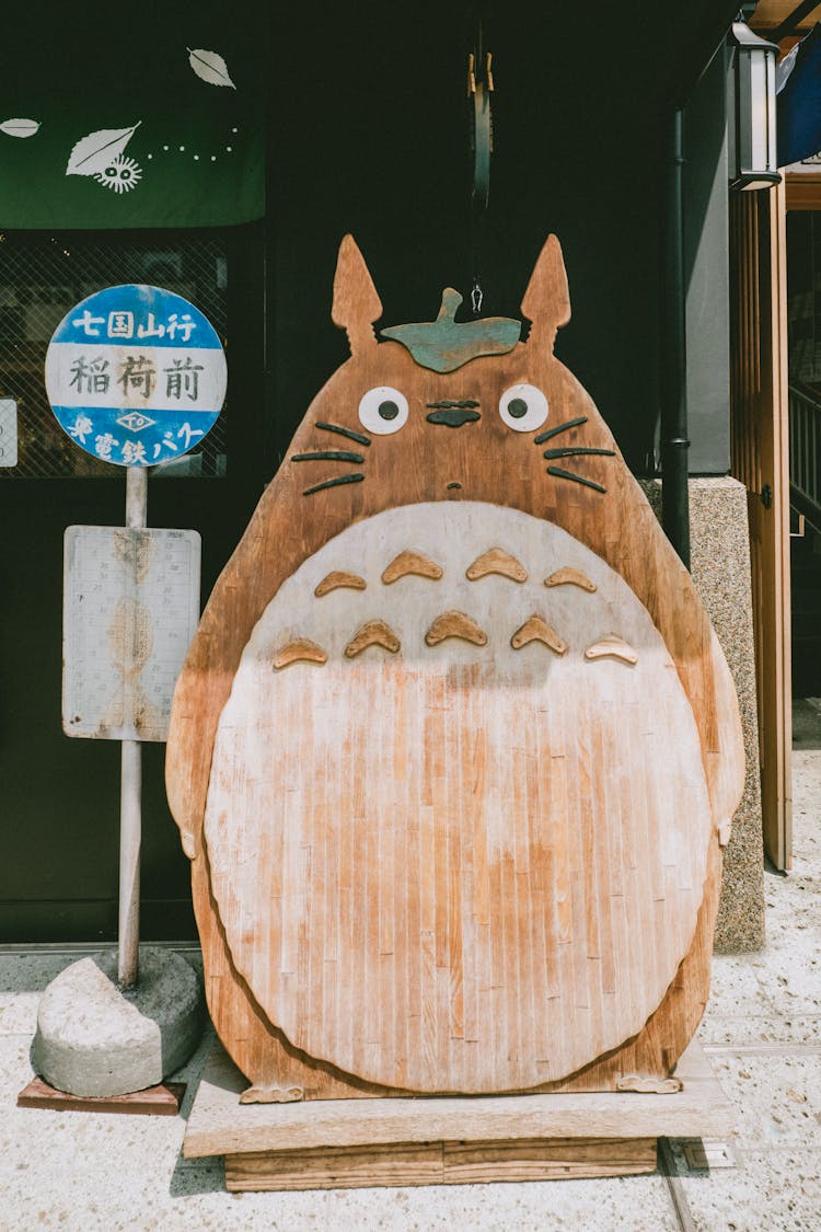 A Wooden Animal Carving Beside A Street   Sign