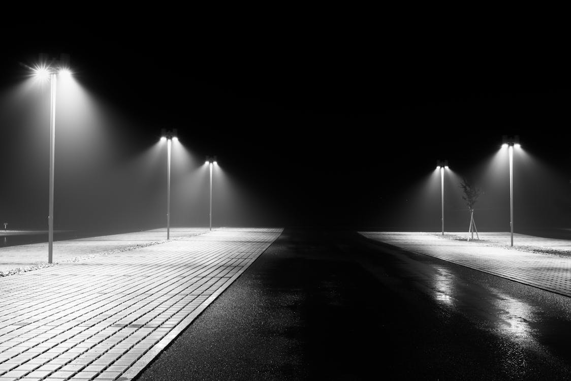 Grayscale Photo of Street Lights at Night