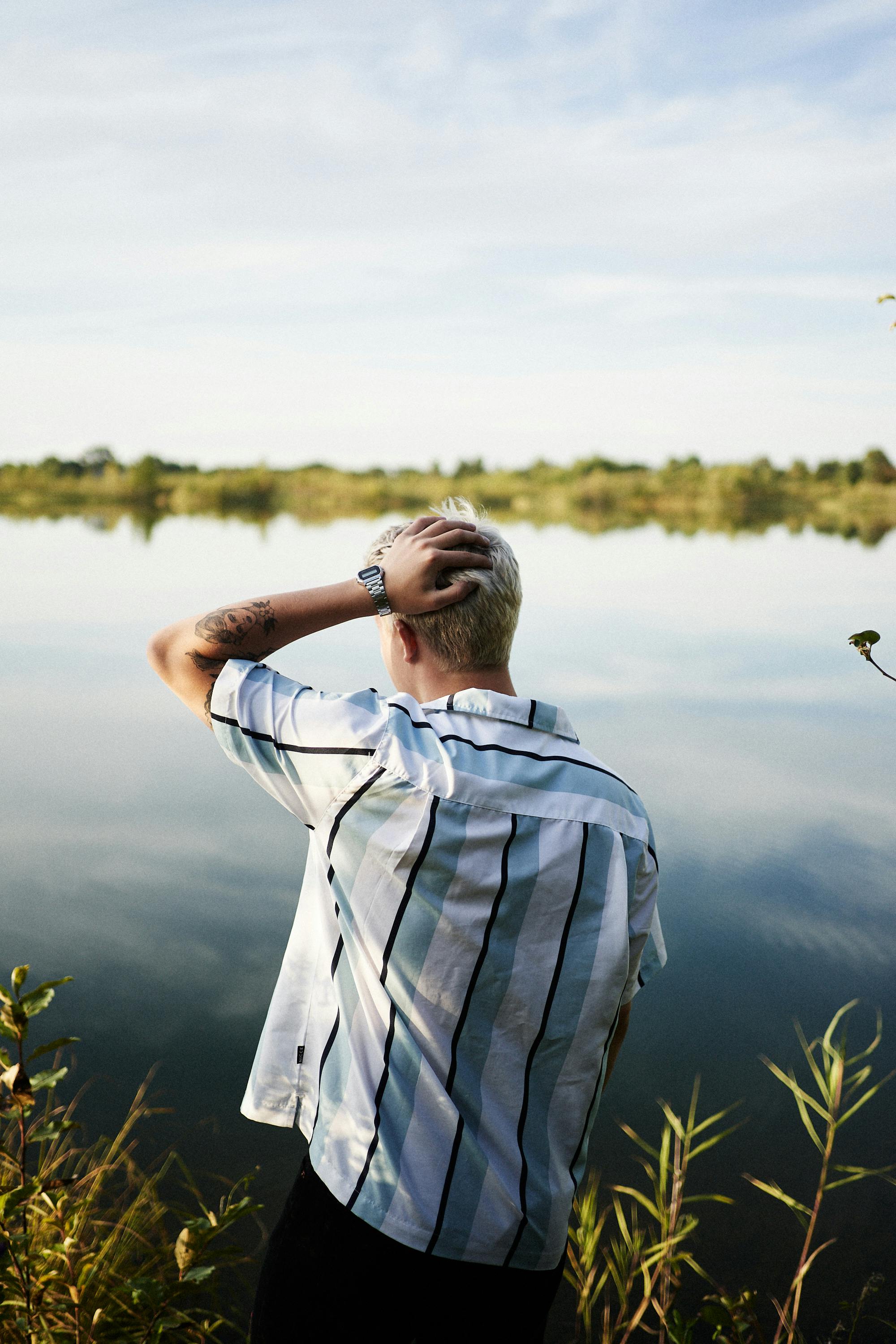 Performer stretching backstage before a show with costumes hanging nearby