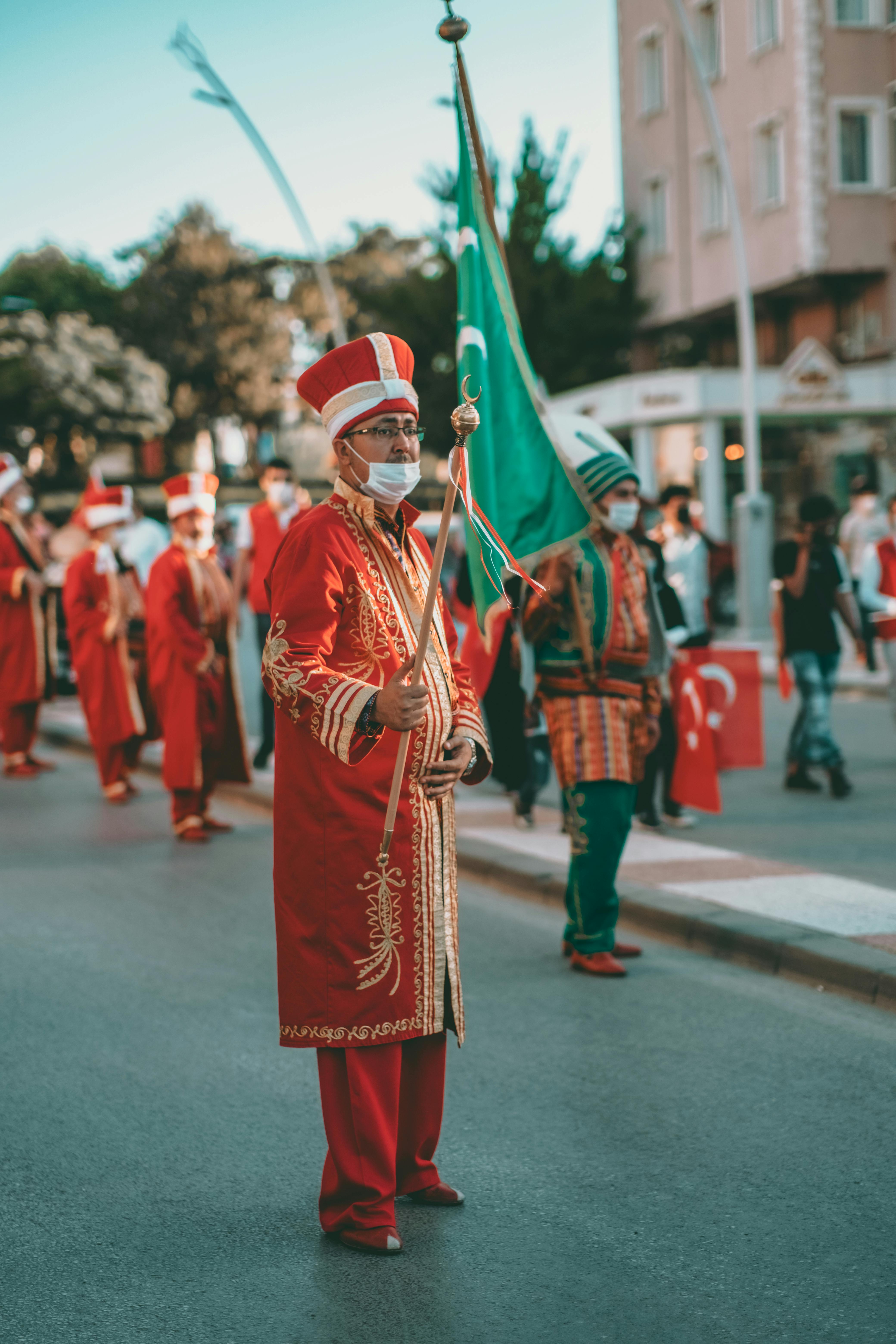 man in red and white traditional dress walking on street