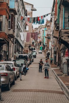 Urban street scene in Istanbul featuring lively local life, architecture, and parked cars.