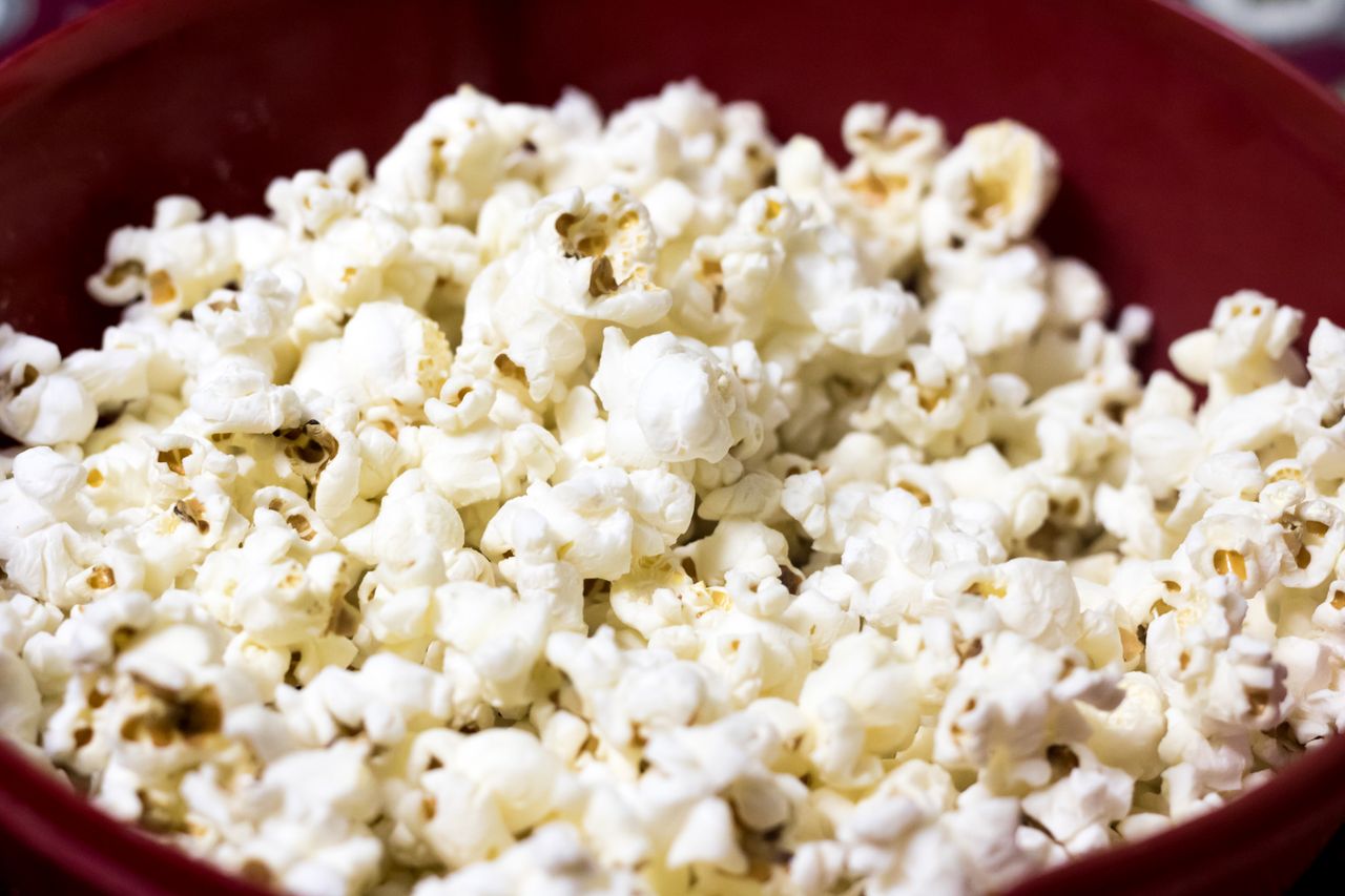 delicious close up of freshly popped popcorn in a red bowl perfect for