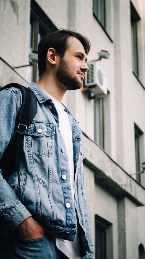 Young Man with a Stubble Standing in Front of a Building in City 