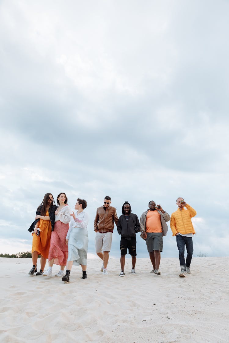 Group Of People Walking On White Sand