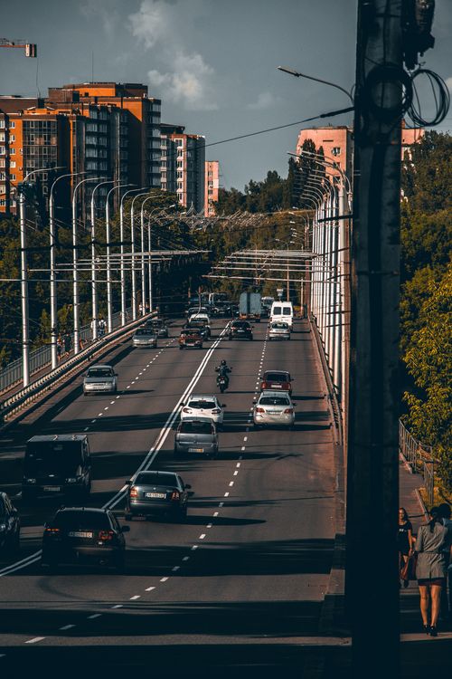 Free A busy city bridge with cars and motorcycles showcasing urban traffic and architecture. Stock Photo