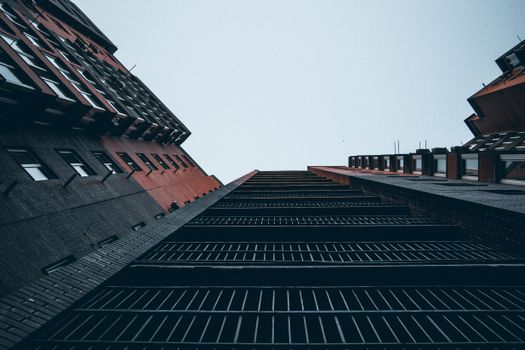 Low angle perspective of modern high-rise buildings with contrasting brick and glass facades.