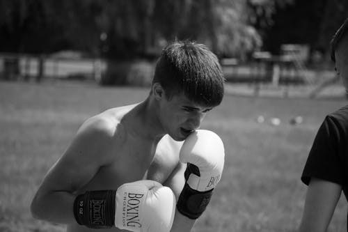 Monochrome Photo of Topless Man Wearing Boxing Gloves