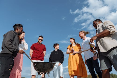 A Group of People Gathered Around a Barbecue Griller