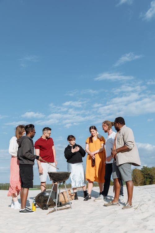 Free Group of People Standing Around a Barbecue Grill Having a Conversation Stock Photo