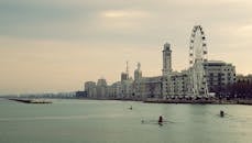 河滨城市景观宁静，有划艇和突出的摩天轮