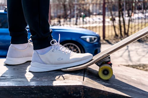 White Sneakers Stepping on a Skateboard