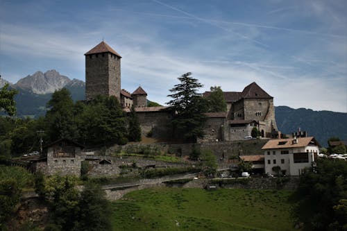 Beige Gemauerte Burg Umgeben Mit Grünen Gräsern Unter Blauem Himmel