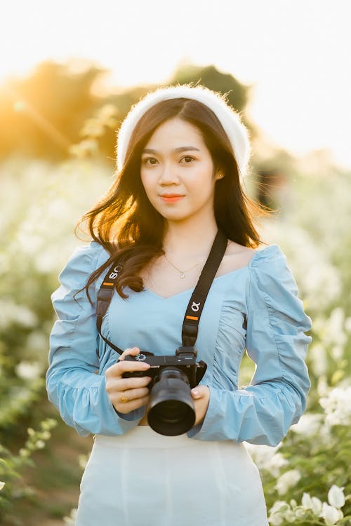 Free Selective Focus Shot of a Beautiful Woman Holding a Black Camera  Stock Photo