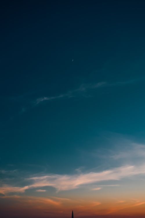 Free Peaceful evening sky featuring a crescent moon and minimalistic cloudscape. Stock Photo