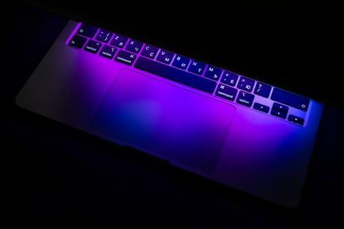 Close-Up Shot of Neon Lights Reflection on a Laptop