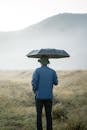 Person in Blue Jacket Holding Umbrella