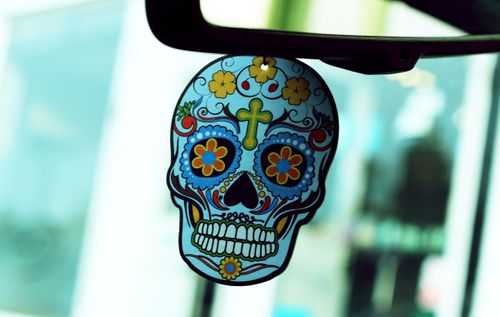 Free Colorful sugar skull decor hanging inside a car, symbolizing Day of the Dead. Stock Photo