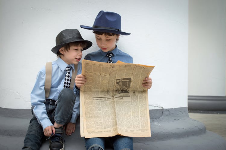 Photograph Of Children Reading A Newspaper