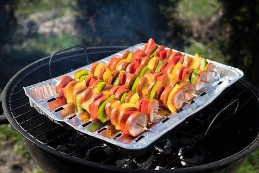 Delicious skewers of vegetables and sausages grilling outdoors for a perfect summer meal.