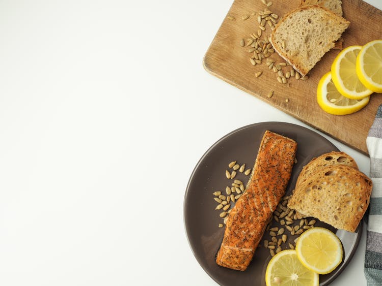 Salmon, Toasted Bread And Sliced Lemons On A Plate