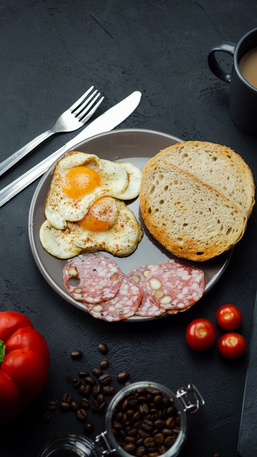 Free A Plate of Delicious Breakfast on a Black Surface Stock Photo