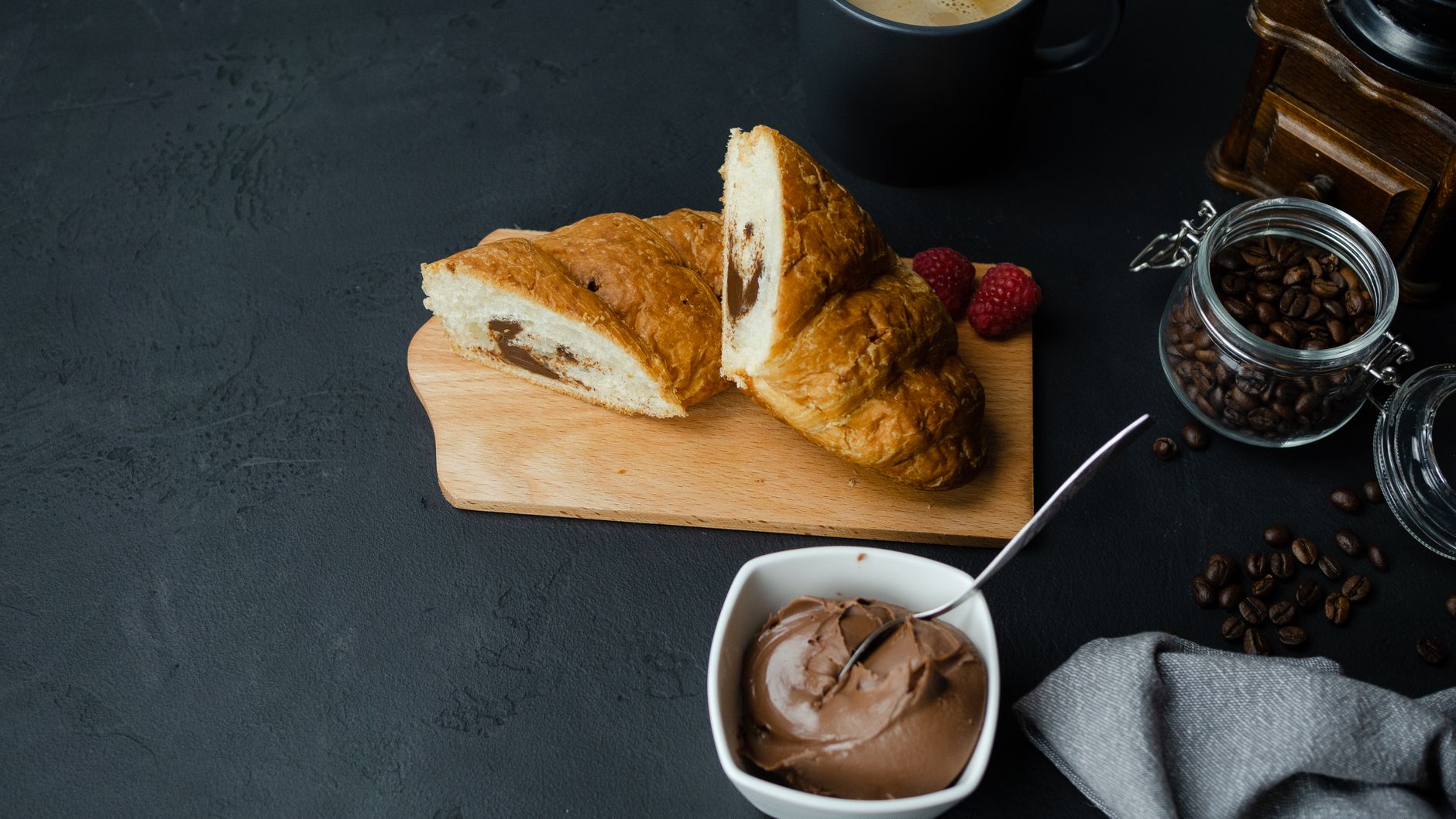 Close-up of chocolate hazelnut spread being spread on a slice of bread with a knife.