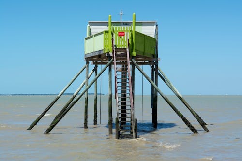 Free Green Wooden Lifeguard Tower by the Beach Stock Photo