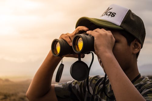 Uomo Che Guarda In Un Binocolo Durante Il Tramonto