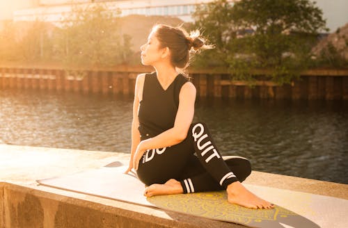 Mujer Vestida Con Traje Negro De Fitness Realiza Yoga Cerca Del Cuerpo De Agua