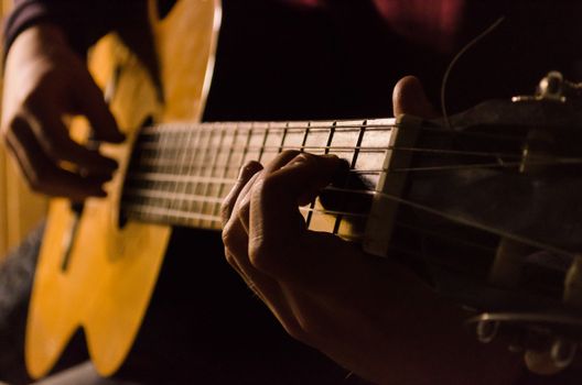 A detailed view of hands playing an acoustic guitar capturing the essence of music creation.