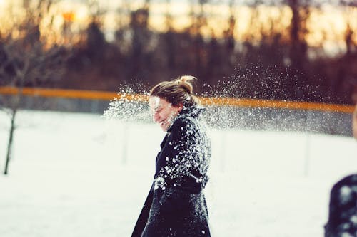 Женщина в черном пальто ударила снежком по голове