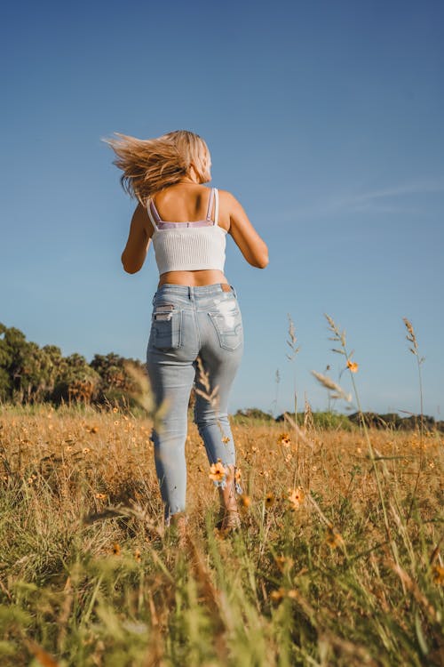 Back View of a Woman in a Grass Field